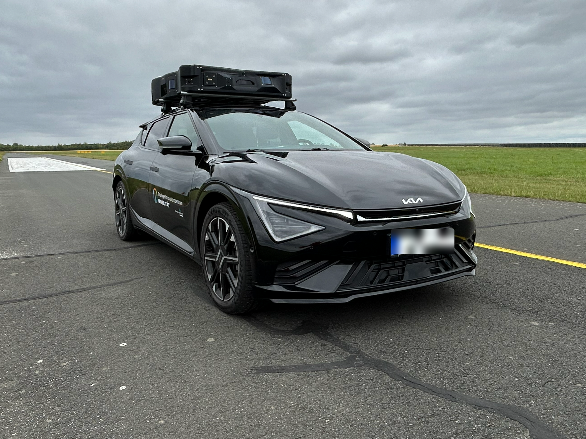 ILMTEX autonomous research vehicle with roof-mounted sensor pod on a test track near Ilmenau